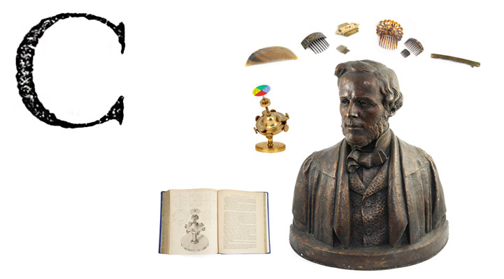 A large printed capital letter C, with a bust of James Clerk Maxwell, combs, a brass instrument and a book.