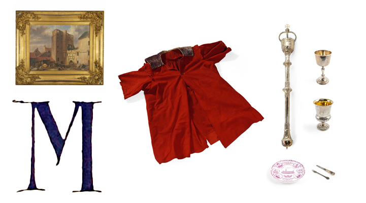 A large blue manuscript capital letter M with a painting, a red gown, a ceremonial mace, silverware and a plate.