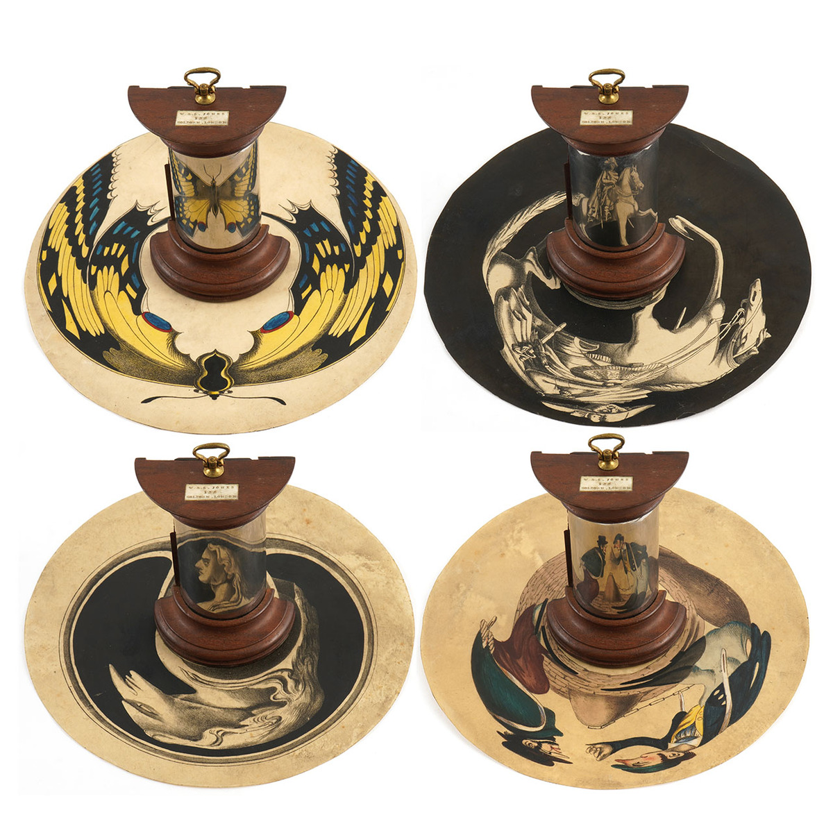 Anamorphic drawings. Four coloured drawings on paper discs with a tall curved mirror placed at the centre: a butterfly, a man on a horse, a bust of a man's head, and two men arguing; the drawings appear normal in the mirror but are stretched out and curved on the paper.