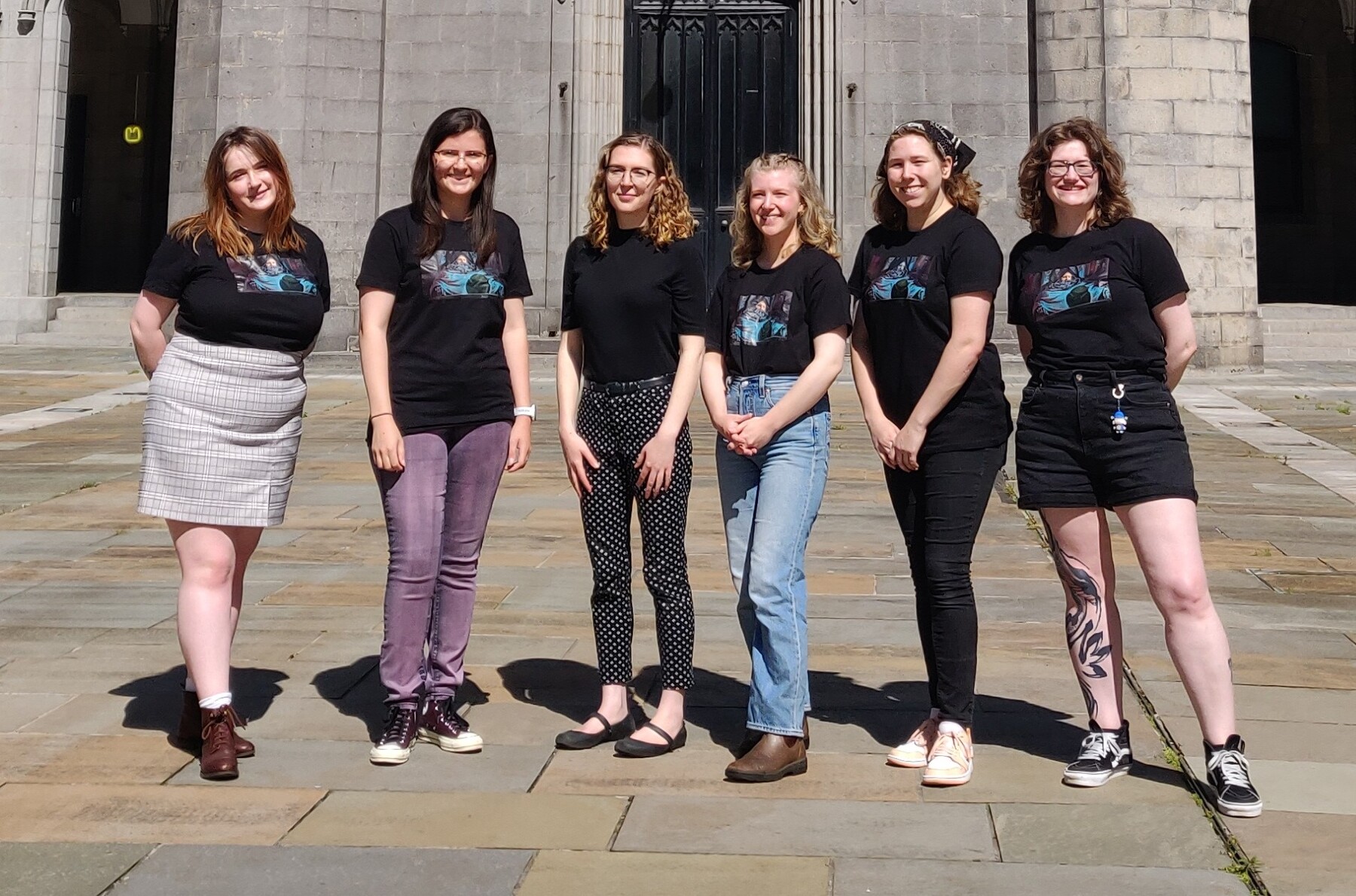 Photo of the six student curators standing in front of a large white building (Marischal College).