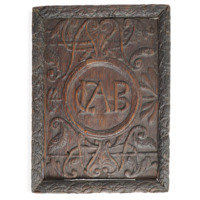Panel. A small rectangular wooden panel carved with foliage and scrolls. In the centre, inside a ring, are the letters C, L and A entwined and B.