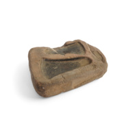 Axe head and chisel mould. A block of sandstone with axe head and bar shaped depressions on the sides.