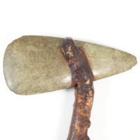 Axe head. A large axe head made of green jadeite, in a long rounded triangle shape.