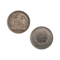 Medal. A silver medal. On one side a woman in classical dress, with a shield decorated with a saltire, sits on a pedestal and places laurels on the heads of two agricultural workers, above the inscription SEMPER ARMIS NUNCET INDUSTRIA. On the other side the inscription Donald Macdonald ERCHLESS For Ploughing 1876 is surrounded by laurels, and around the edge is the inscription HIGHLAND AND AGRICULTURAL SOCIETY OF SCOTLAND.