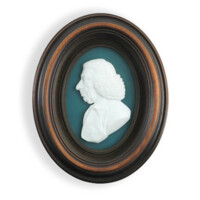 Portrait medallion. The face and upper torso of an elderly white man with a curly wig in profile, sculpted in relief, made of a smooth white material. The portrait is on a blue background in an oval shaped dark wooden frame.