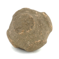 Carved stone ball. Roughly the size of a tennis ball. Brown, coarse stone ball with six small squarish flat knobs arranged equidistant to each other.