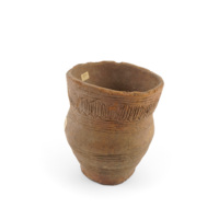 Beaker. A small earthen ware pot. The base is about half the size of the opening and the body flares out in the middle before contracting again. Decorated with incised bands of horizontal lines and a band of vertical and zig zag lines near the rim.
