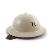 ARP helmet. A white metal helmet with a wide brim and a bowl shaped top, with the letter R painted on.