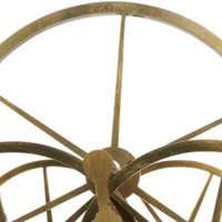 Close up of a large brass wheel on a steel axel resting on four smaller wheels.