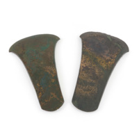 Axe heads. Two flat bronze axe heads, covered in green rust.