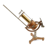 Solar pyrheliometer. A large instrument made of steel, brass and wood. Three small fan shaped steel plates which can be rotated are positioned over a long brass cylinder which extends from a squat wooden cylinder, suspended in a ring mount allowing the apparatus to be rotated in multiple directions.