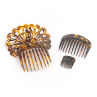 Combs. Three mottled translucent orange and brown tortoiseshell combs, clockwise from left: an large ornate comb decorated with scrolls, a medium sized comb, a small fine comb.