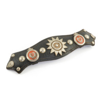 Harness ornament. A piece of black leather with metal studs and badges. In the centre is a badge consisting of a dot, a ring and hearts arranged in a ring, there are also two badges composed of a red disc with a horseshoe in the middle.