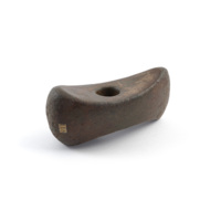 Axe head. A block of polished grey stone with a canoe like profile, and a perfectly circular hole about the size of a two pence piece drilled vertically through the centre.