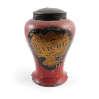 Tobacco jar. A large painted red jar almost a foot tall, vase shaped with a flared base and a body that bulges out toward the top. Painted on the front is a gold label with the appearance of drapery with the word MIXTURE on it.
