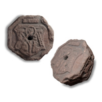 Keystone. A large, thick octagonal block of reddish brown stone about a foot wide with a hole in the centre. On the sides are carvings of lambs, and on the surface is carved a cross with a heart between the arms, a ladder and a human figure.