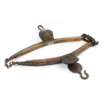 Haims. Two large curved pieces of wood joined by a chain at one end and a leather belt at the other. Each wooden pieces has a metal plate screwed to its outer surfaces and a leather pad with a metal hook.