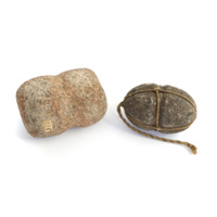 Net weights. Two stones, one cuboid, the other ovoid, both with grooves cut across the middle to allow cords to be tied around them.