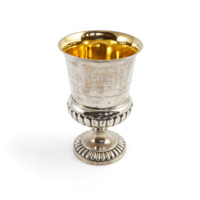 Cup. A fat silver cup with a stem and scalloped decoration around the base and foot.
