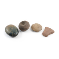 Stone charms. Four charms, left to right: a polished brown and blue oval pebble, a round stone mace head, a flat disc, a miniature stone axe head.