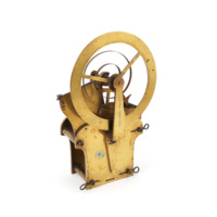 Clock movement. A small brass contraption consisting of wheels, cogs, plates, and a spring.