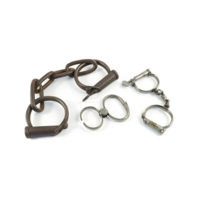 Manacles. Three sets of iron and steel manacle, left to right: large manacles for the ankles with a chain between them, small snip manacles with a hinge rather than a chain, regular handcuffs with a chain between them.
