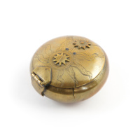 Tobacco box. A round brass box with components on the lid shaped like a star and an anthropomorphic sun. The sun&#039;s rays are engraved onto the lid.