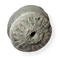 Rotary quern. Two fat discs of coarse grey stone almost half a metre wide, the upper disc having a hole in the centre around which is carved a raised ring. Carved grooves radiate from the centre.