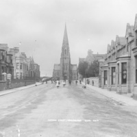 Victoria Street, Fraserburgh. A long wide street lined with small two storey stone houses, with a church at the end.