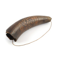 Touting horn. A small brown horn with a plain cord. The horn is decorated with incised knotwork patterns.