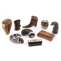 Snuff mulls. Nine snuff mulls in various shapes: boxes made of wood and inlaid horn and ivory, spiral shaped horns, a miniature wooden shoe, a horn with the tip carved into a monster&#039;s head, and a repurposed bronze axe head.