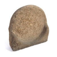 Bannock stone. A large piece of brown stone, with a circular depression carved out of it. The base is flat allowing the stone to stand with the circular depression upright.