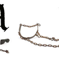 A large, printed capital letter A with stone, bronze and iron axe heads, a bull harness and a tin opener.