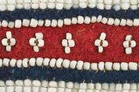 Beaded Belt Close Up. White beads on navy blue and red stroud cloth.