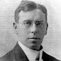 Photograph of Henry Williamson Gray. A man with short hair and glasses, wearing a white shirt faces the camera.