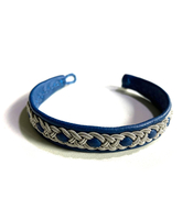 Blue bracelet with silver knotwork design on top.